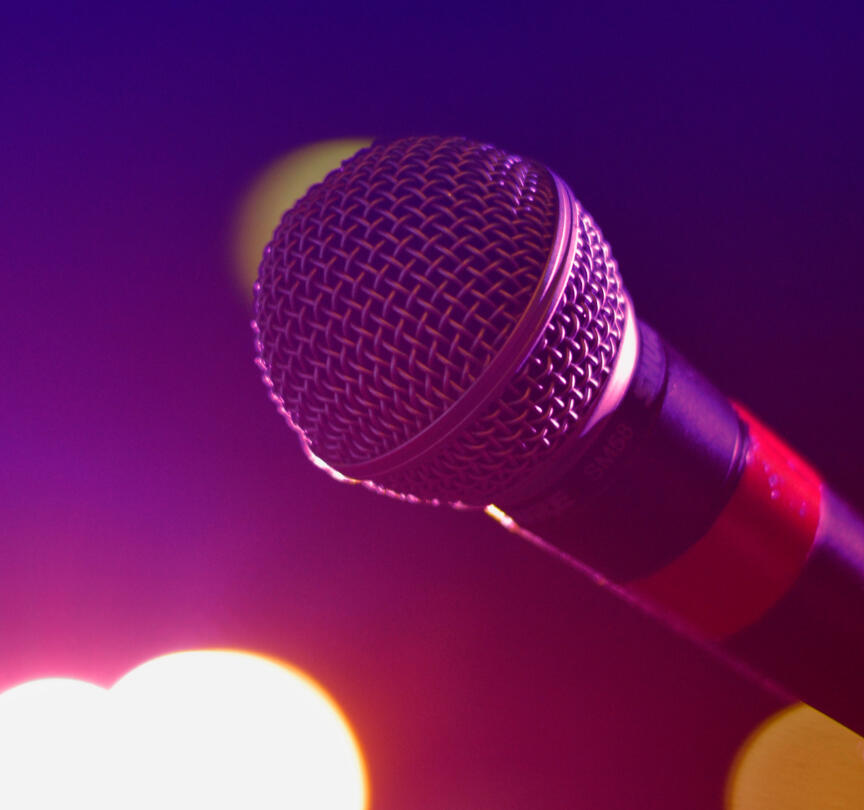 Microphone on stage symbolizing storytelling, confidence, and finding your voice with Nader Eid